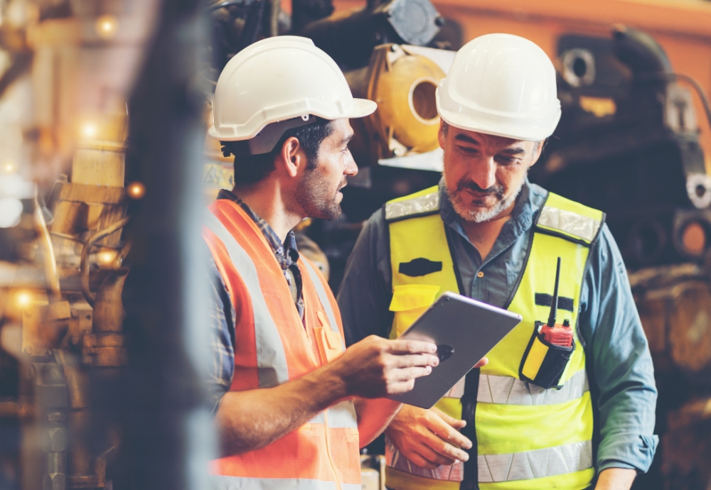 two construction workers talking over clipboard